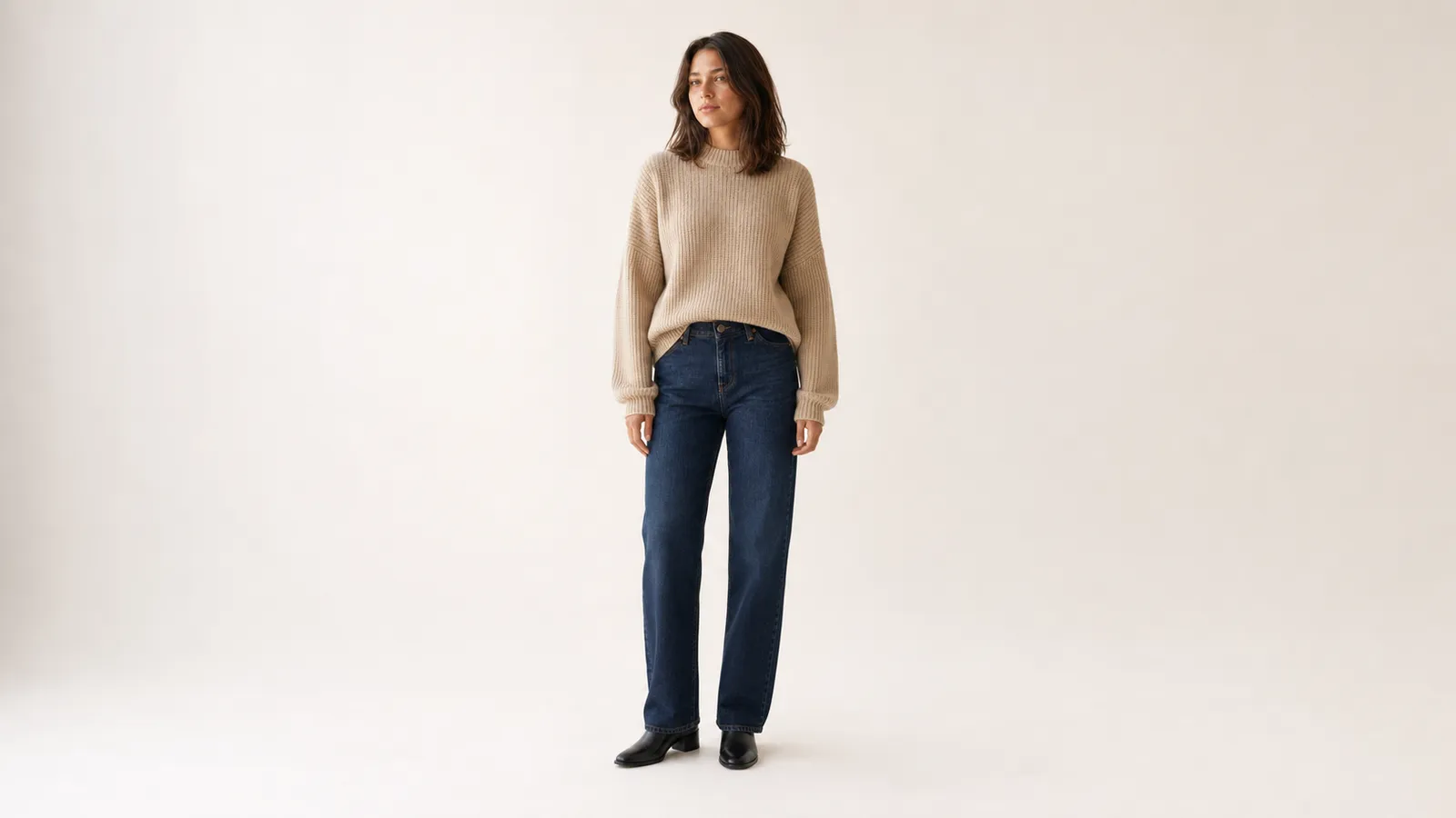 An AI-generated model in a beige knit sweater on a clean seamless studio backdrop, framed and lit for an ecommerce product listing